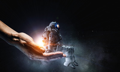 Wall Mural - spaceman in male hand. mixed media