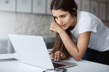 Wall Mural - Close up of young woman using a laptop computer to apply for a job online.