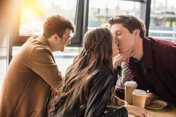 Wall Mural - heterosexual couple kissing at cafe