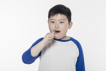 Wall Mural - healthy asian boy hand hold a tooth brush isolated white.