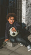 © supamotion - African American  sitting at porch with soccer ball