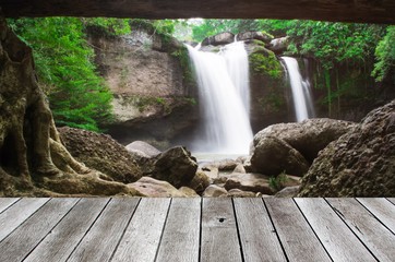 wooden floor terrace or plank desk with beautiful nature waterfalls in deep forest background, copy space for display of product or object presentation