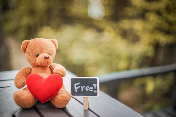 Wall Mural - bear doll and red heart and free plate on the table with dramatic tone