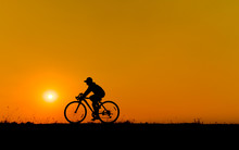 Silhouette Of Young Woman Cyclist On Sunset Sky With Riding Along The Prairie At Yellow Evening Horizon Sea Yellow Sunset Heaven Background Outdoor