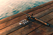 Fishing rod and lures on a wooden dock.