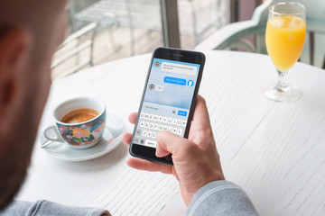Wall Mural - sending messages from a mobile phone. man use smartphone to schedule a lunch with a business partner