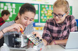 © highwaystarz - Female Pupils In Science Lesson Studying Robotics
