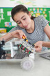 © highwaystarz - Female Pupil In Science Lesson Studying Robotics