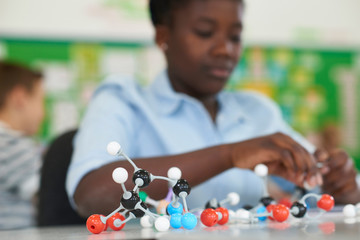 Wall Mural - female pupil using molecular model kit in science lesson