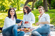 © romaset - Young beautiful girls eating strawberries in the park