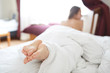 © vitaliymateha - back view of young woman lies in bed early in the morning and with a satisfied smile stretches. focus on the feet