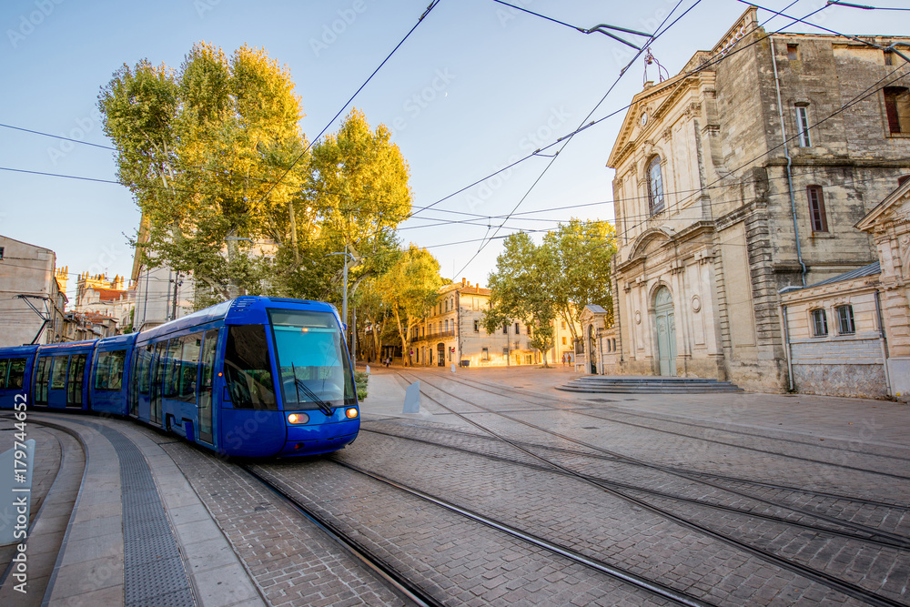 Street view with Saint-Charles chapel and tram during the sunset in Montpellier city in southern France - obrazy, fototapety, plakaty 