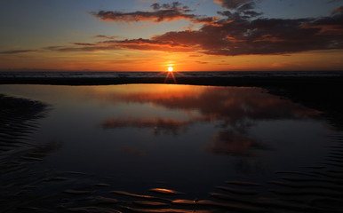 Sunset reflected in beach pool on Blackpool beach