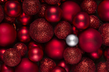Red Christmas Ornaments. One Different White Christmas Ball Among A Large Group Of Red Baubles. The Difference, Contrast Concept. Full Frame. Top View