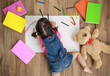 © DN6 - Adorable little girl drawing artwork. Studio shot top view of child on floor