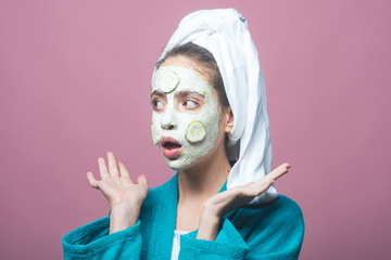 Wall Mural - Woman with cucumber mask on surprised face on violet background