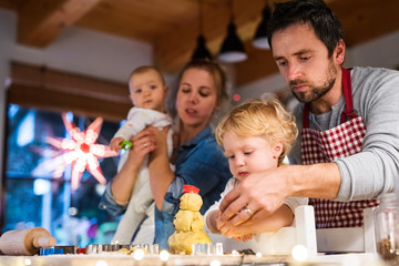 Canvas Print - Young family making cookies at home.