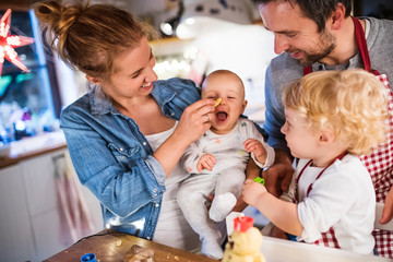 Canvas Print - Young family making cookies at home.