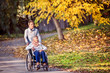 © Halfpoint - Senior man and woman in wheelchair in autumn nature.
