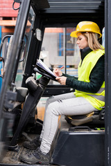 Wall Mural - Female forklift truck driver outside a warehouse.