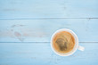 Coffee cup on light blue wooden background. Top view. 