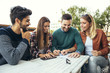 © Mediteraneo - Group of four friends having fun a coffee together. Two women and two men at cafe talking laughing and enjoying their time