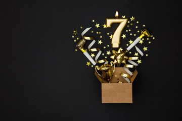 Wall Mural - number 7 gold celebration candle and gift box background