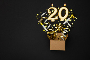 Number 20 gold celebration candle and gift box background