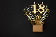 Number 18 gold celebration candle and gift box background