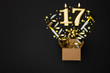 Number 17 gold celebration candle and gift box background