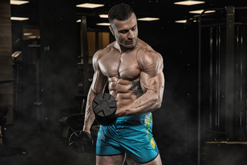 man in gym. Muscular bodybuilder guy doing exercises with barbell. Strong person. Sports background. Young athlete ready for weight lifting training.