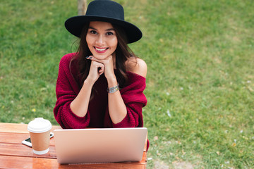 Poster - Portrait of a smiling pretty asian girl using laptop computer