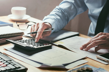 Fototapete - businessman working on desk office with using a calculator to calculate the numbers, finance accounting concept