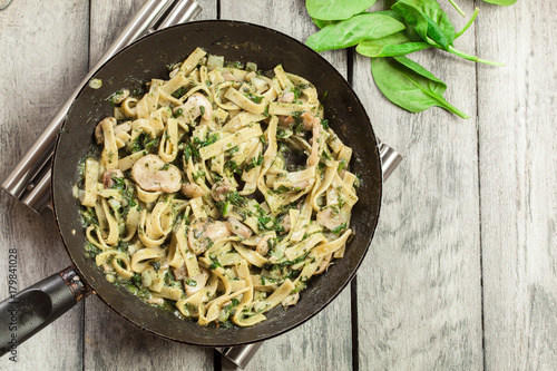 Cuadros en Lienzo Tagliatelle pasta with spinach and mushrooms on a pan.