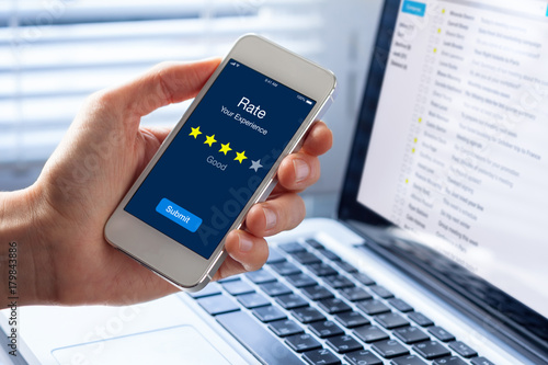 Fotografía Person rating his experience with stars on smartphone app screen