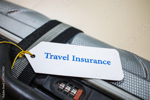Fotografie, Obraz Travel Insurance tag on suitcase near numeric combination lock with tag tied letters enjoyable trip