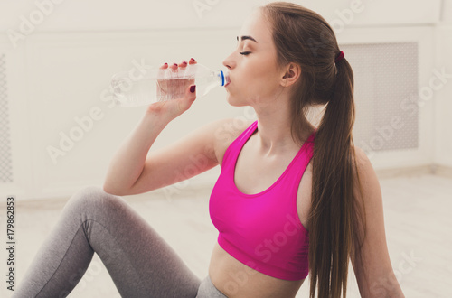 Zdjęcie XXL Sprawności fizycznej kobiety woda pitna przy gym na białym tle