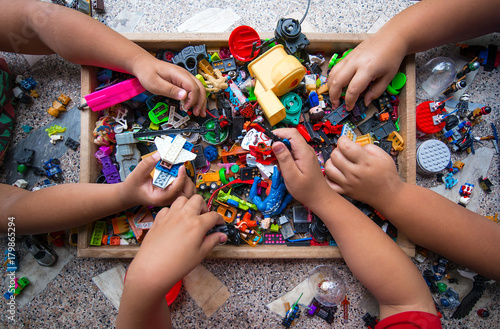 The hands of many children who are playing toys together. Tableau sur Toile