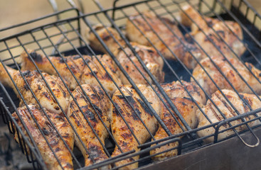 Sticker - Chicken legs cooking in barbecue on smouldering carbons.