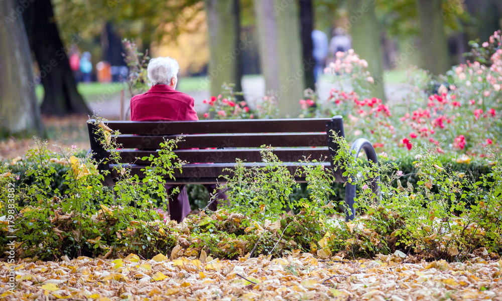 Depressed and sad old woman sitting alone on bench in park Stock Photo ...