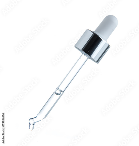 Fotomural transparent glass pipette with falling drops close-up on white background