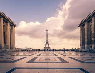 Wall Mural - Eiffel tower, Paris symbol and iconic landmark in France, on a cloudy day. Famous touristic places and romantic travel destinations in Europe. Cityscape and tourism concept. Long exposure. Toned