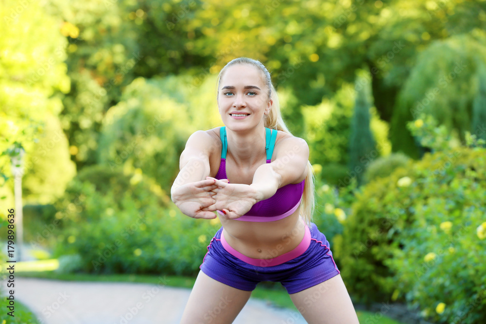 Sporty young woman exercising in park