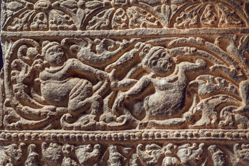 Wall Mural - Stone figures of people on carved wall inside the 6th century cave temple, art of India