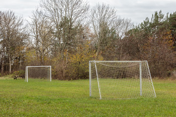 Small football field with two goals outdoors on green grass