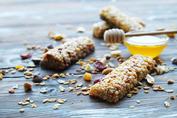 Wall Mural - Healthy granola bars with fruits, nuts and honey on wooden background.