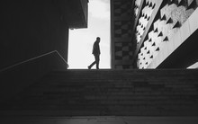 Silhouette Of A Walking Man In A City. Black And White Photo