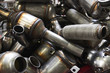 Industrial background. Stacks of new exhausts and silencers mufflers car before distribution and retail. Detail of a new automotive components in stainless steel. Close up.
