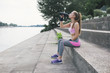 © Westend61 - Sporty woman drinking water at the riverbank