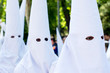 Penitents (Nazarenes) wearing white masks in a Holy Week procession in Seville (Spain)